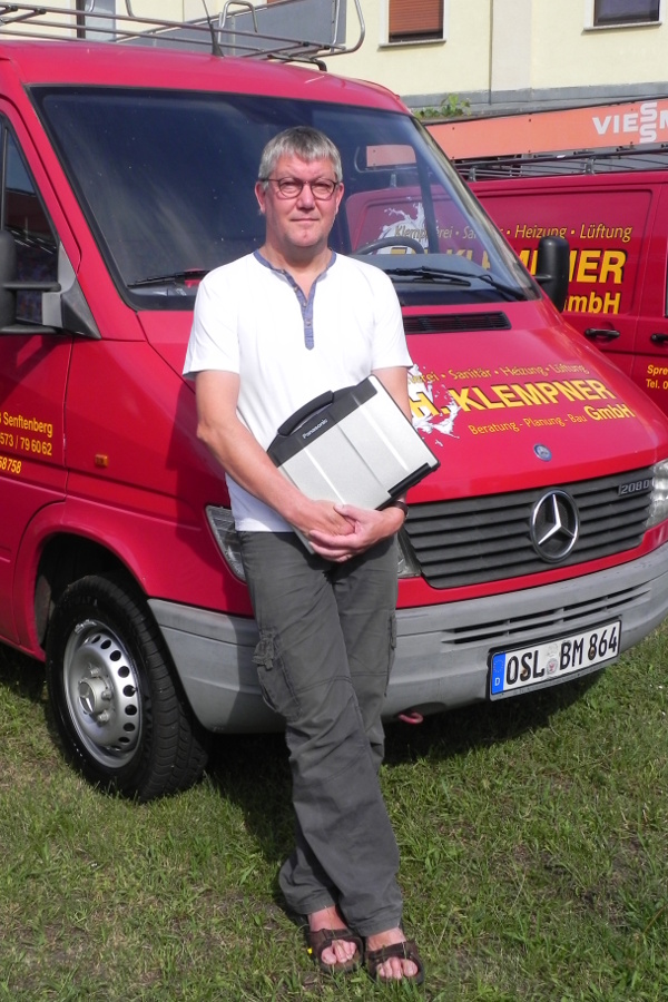 Foto - Thomas Hoffmann mit Firmenauto im Hintergrund